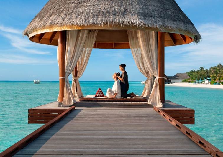 Guest enjoying a relaxing massage at the outdoor Sala with the lagoon view at Anantara Dhigu Maldives Resort