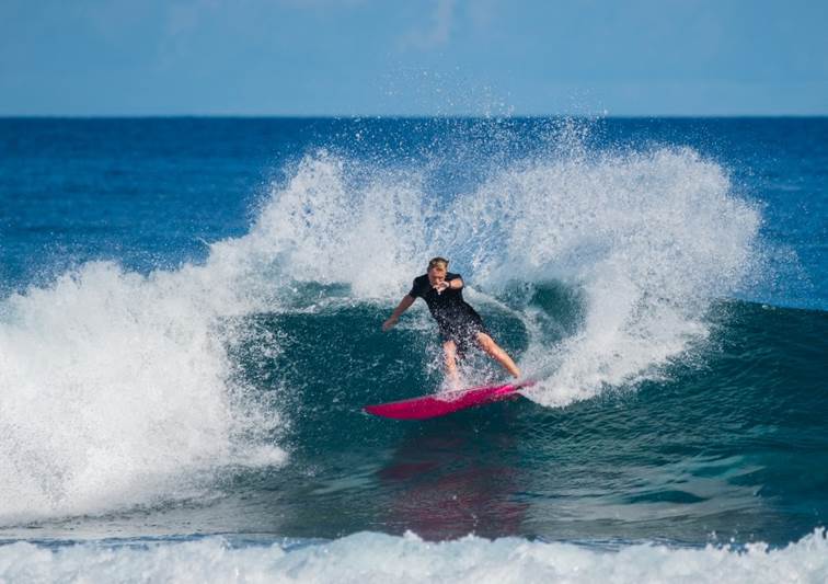 Surfer riding a wave near Anantara Dhigu Maldives Resort