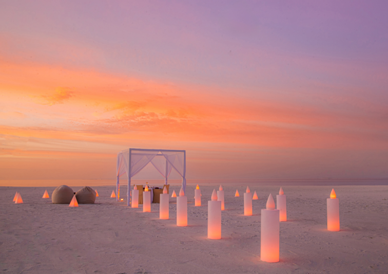 Sunset private dining on the beach at Anantara Kihavah Maldives