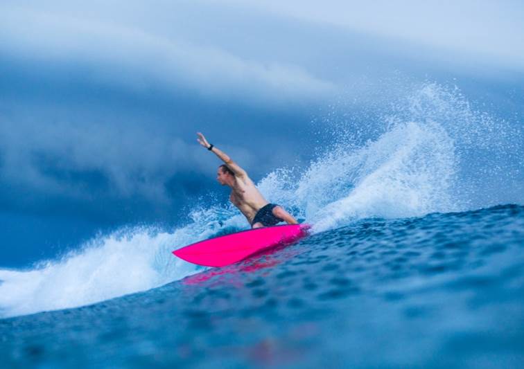 Surfer riding a wave near Anantara Veli Maldives Resort